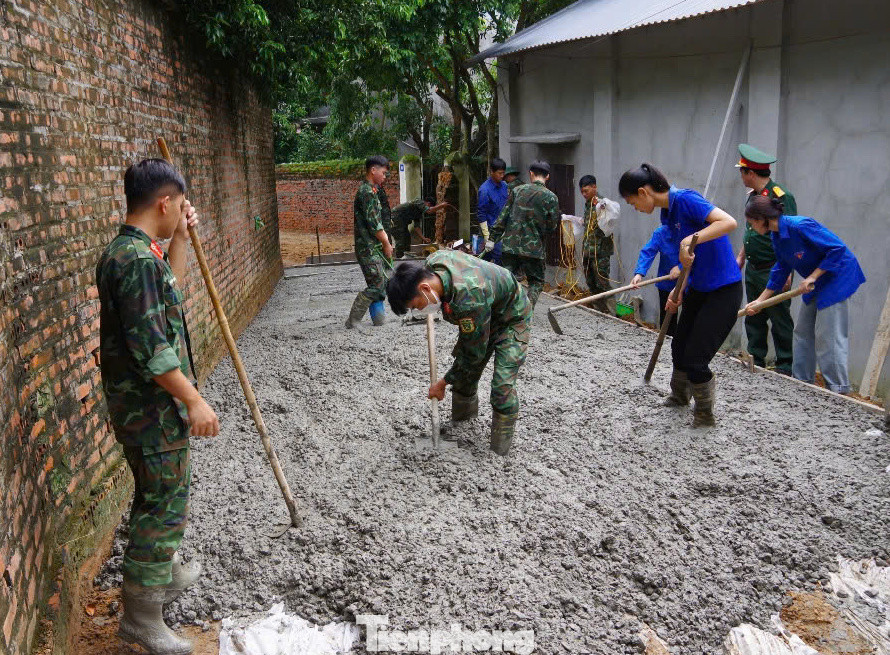 Chiến sĩ Công binh Lữ đoàn 249 cùng với đoàn viên, thanh niên giúp nhân dân xã Thuỵ An (huyện Ba Vì, TP. Hà Nội) đổ bê tông, sửa chữa đường giao thông do lũ sau bão số 3 cuốn trôi.
