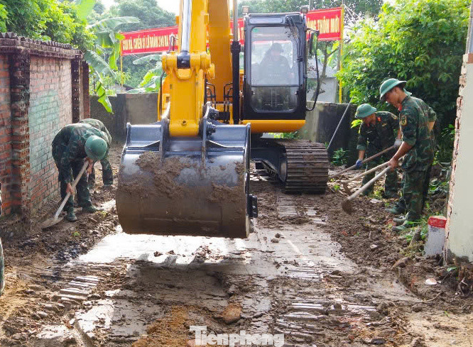 Chiến sĩ Công binh Lữ đoàn 249 cùng với đoàn viên, thanh niên giúp nhân dân xã Thuỵ An (huyện Ba Vì, TP. Hà Nội) đổ bê tông, sửa chữa đường giao thông do lũ sau bão số 3 cuốn trôi.