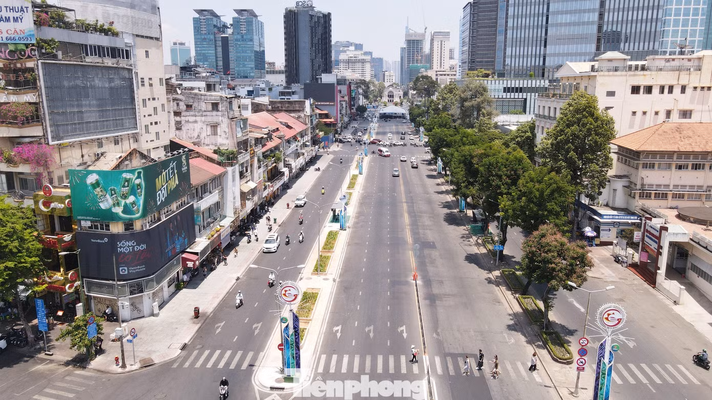 Hàng cây hiện hữu trên đường Lê Lợi (bên phải) và khu vực vừa tái lập mặt bằng sau khi thi công dự án metro số 1 (bên trái). Ảnh: PV