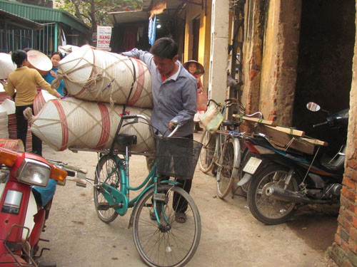 Anh Tuấn (xã Phương Trung, huyện Thanh Oai, Hà Nội) đang đưa số nón đã mua được về nhà. Sau đó số nón này sẽ được phân phối đi nơi khác.