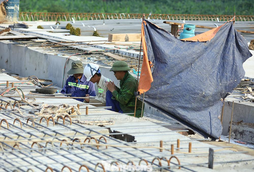 Làm việc ngoài trời nóng trong thời gian dài, các công nhân phải căng bạt che chắn ánh nắng mặt trời