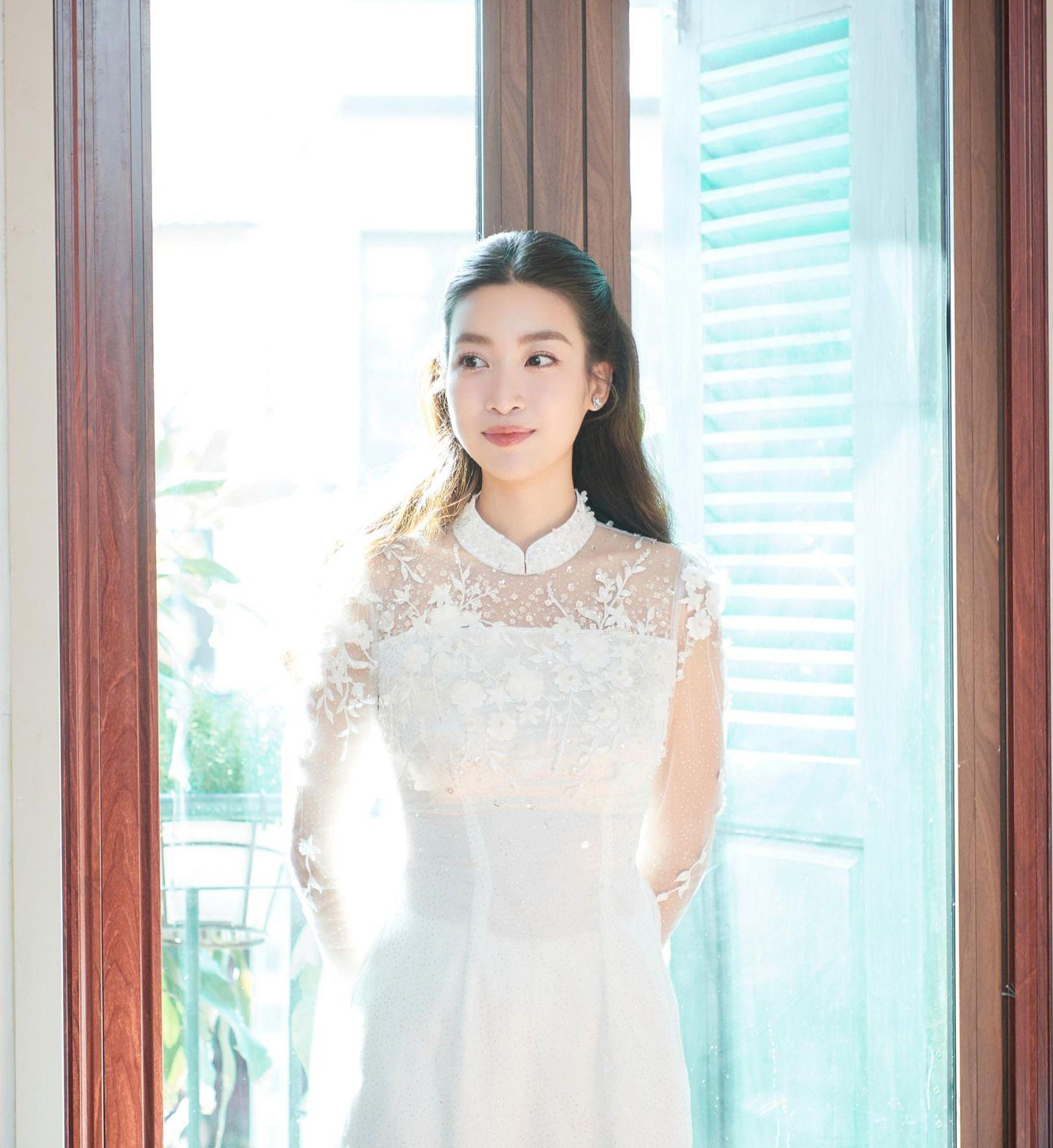 Trong lễ ăn hỏi, Đỗ Mỹ Linh mặc chiếc áo dài tông màu trắng trang nhã, thanh lịch do Hoa hậu Ngọc Hân thiết kế. Bộ áo dài mang tên Thanh Ngọc Ban Mai, là món quà mà Ngọc Hân dành cho đàn em trong ngày trọng đại.