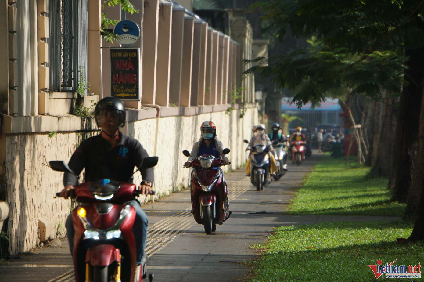 Người dân leo xe lên lề đường Lê Duẩn để di chuyển do lòng đường không thể chen