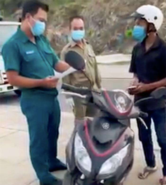 Lực lượng chức năng kiểm tra giấy tờ của anh Trần Văn Em (bên phải ảnh). Ảnh chụp lại clip.