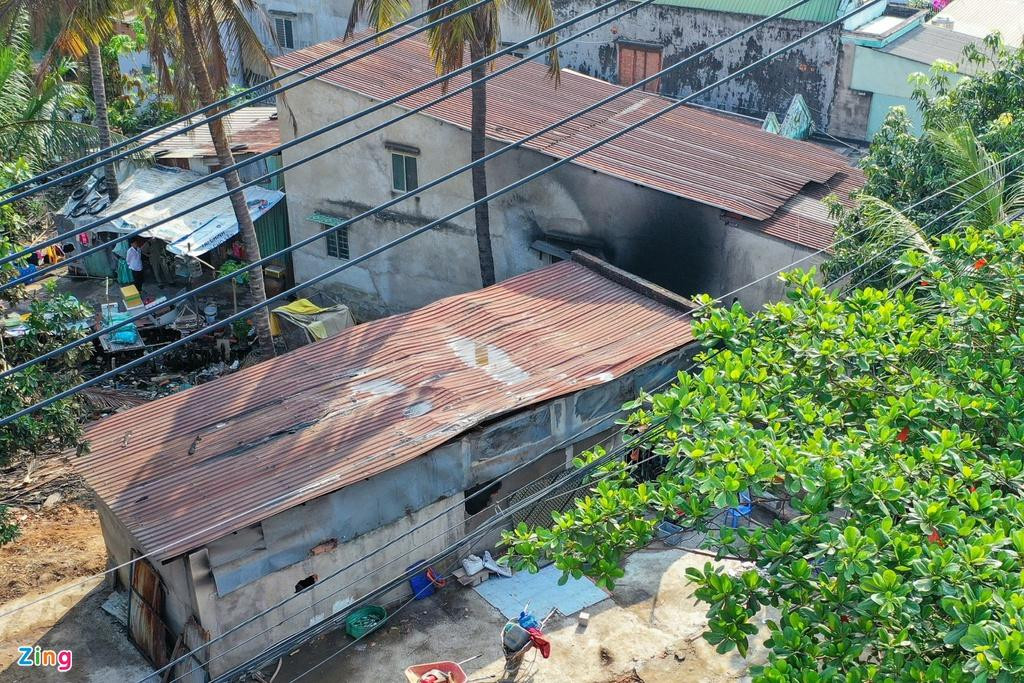Căn nhà bị cháy rộng khoảng 60 m2 cách cảng Cát Lái chừng 2 km, xung quanh khá thoáng. Căn nhà được xây tạm bằng 3 bức tường xi măng, lộp mái tôn, cao khoảng 4 m, chỉ một cửa ra vào. Bên phải ngôi nhà là mảnh đất trống, bên trái có nhiều nhà. Ảnh: Zing