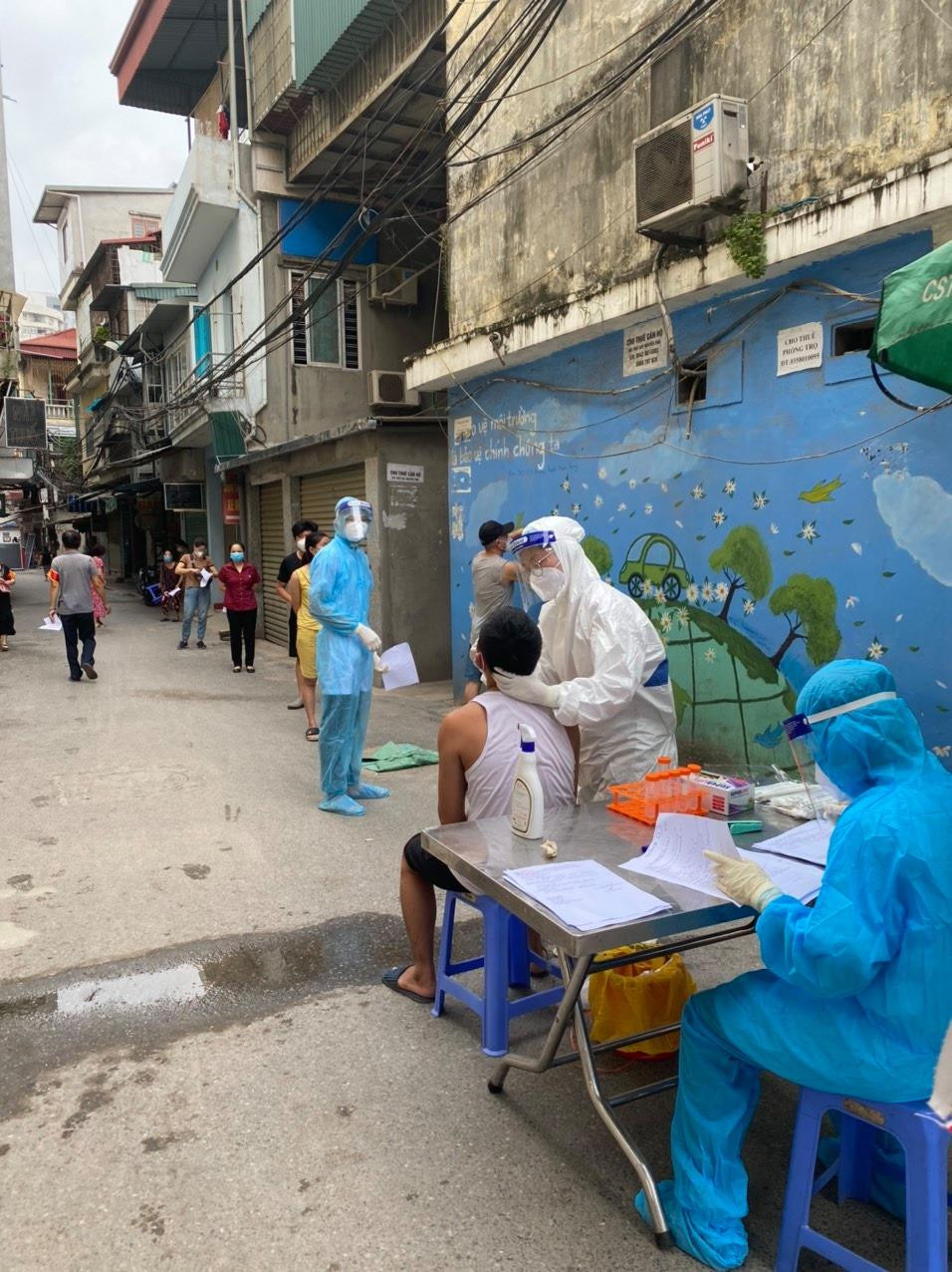 Nhân viên y tế lấy mẫu xét nghiệm cho người dân trong khu vực cách ly Nhân viên y tế lấy mẫu xét nghiệm cho người dân trong khu vực cách ly