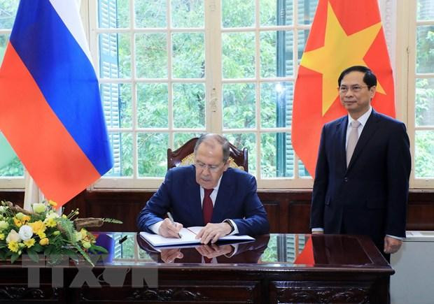 Bộ trưởng Ngoại giao Bùi Thanh Sơn chứng kiến Bộ trưởng Ngoại giao Nga Sergey Lavrov ghi lưu bút. (Ảnh: Lâm Khánh/TTXVN)