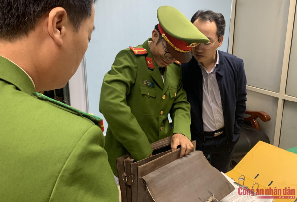 Cán bộ Công an mở chiếc cặp da màu nâu bí ẩn.