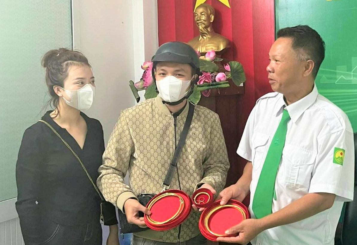 Dưới sự chứng kiến của lãnh đạo công ty, tài xế Dũng trao lại 1,8 cây vàng cho hành khách.