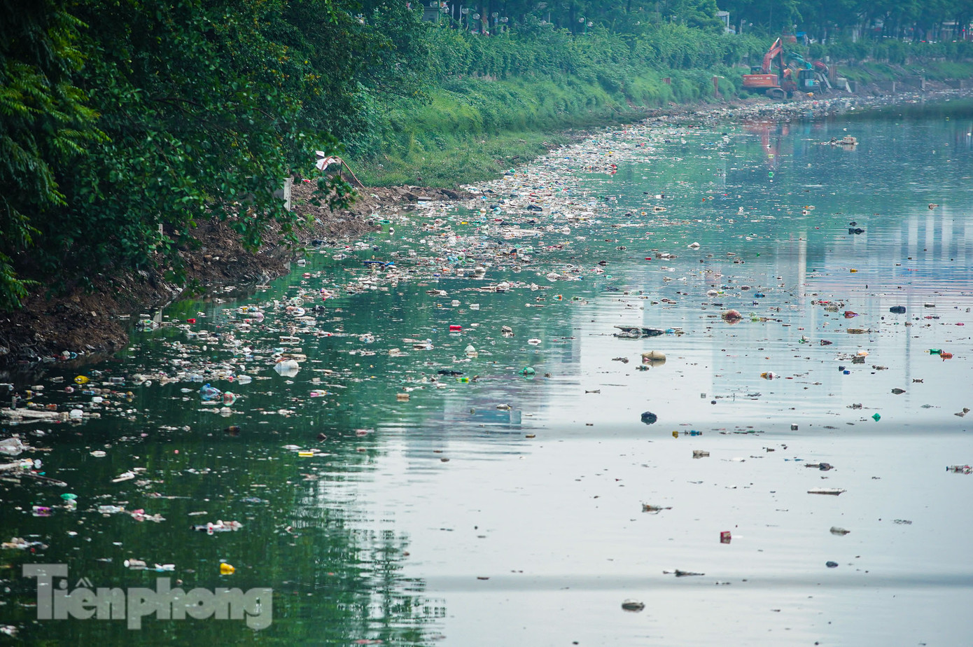 Cảnh rác thải nổi lềnh phềnh, bốc mùi hôi thối trên mặt nước sông Tô Lịch khiến người dân đi qua, sinh hoạt tại khu vực gần sông không khỏi ngán ngẩm. Trong ảnh: Cảnh sông "ngập" rác tại khu vực gần nút giao Láng - Lê Văn Lương.