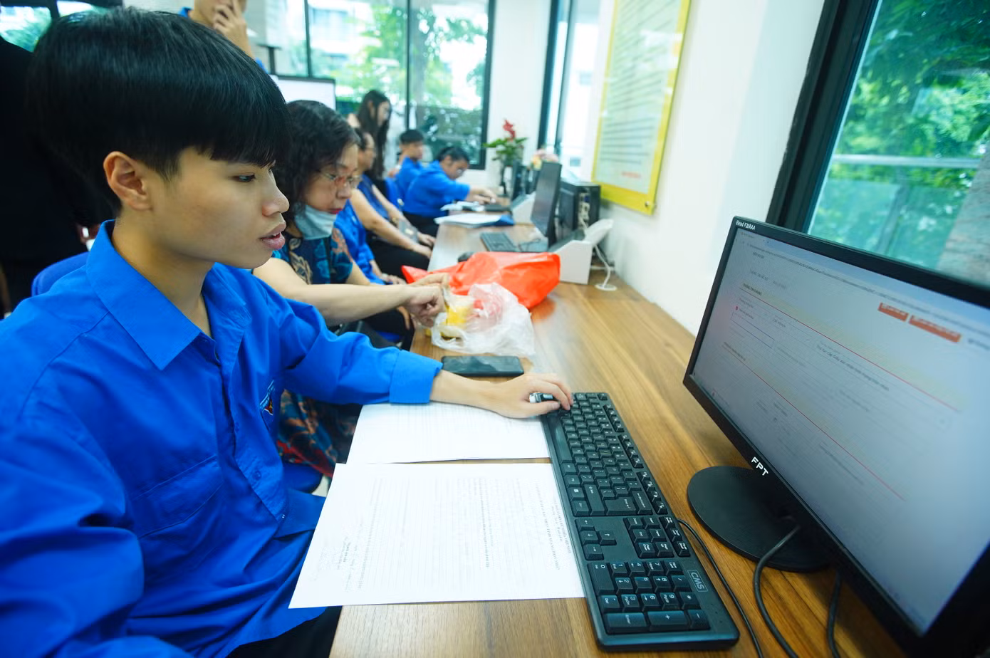 Tình nguyện viên "trực chiến" bên khu vực máy tính, giúp người dân kê khai online, nhập dữ liệu nhanh chóng.