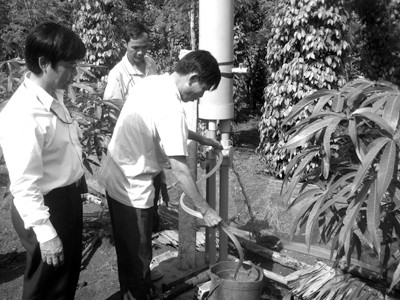 Các thành viên CLB tiêu năng suất cao tìm hiểu bình áp lực trong hệ thống tưới nhỏ giọt. Ảnh: Phạm Tùng