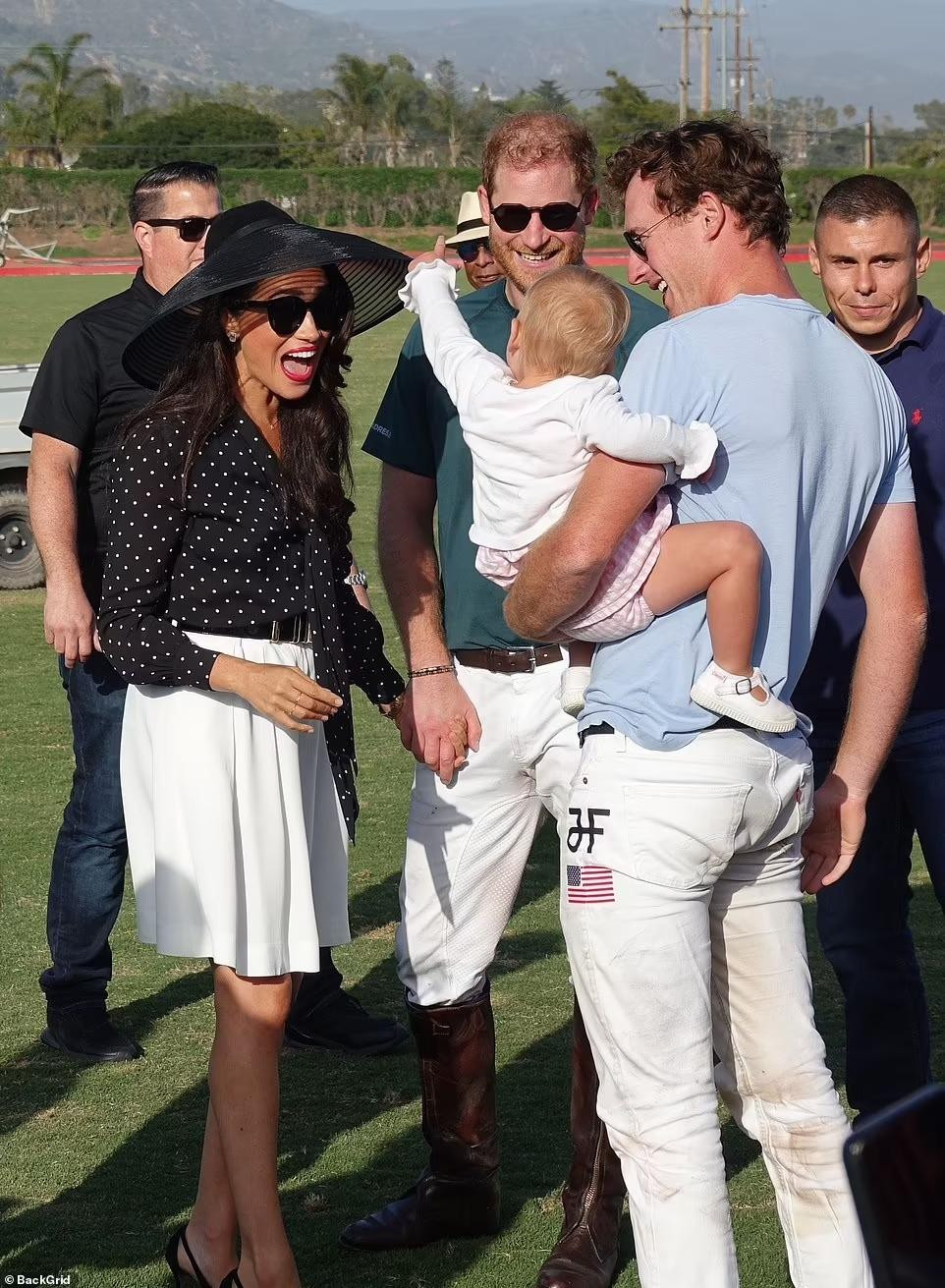 Là cha mẹ của hai con nhỏ, Harry và Meghan rất phấn khích khi giao lưu với một em bé trên sân cỏ.