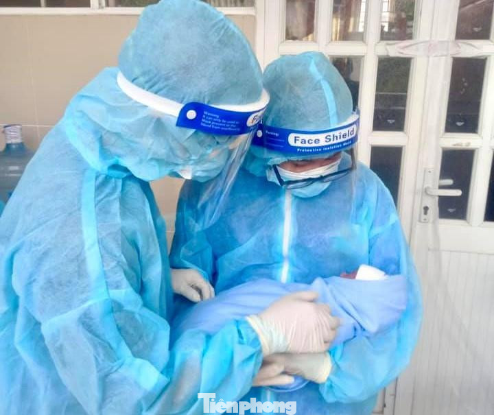 Hai tình nguyện viên và bé trai vừa ra đời trong khu cách ly