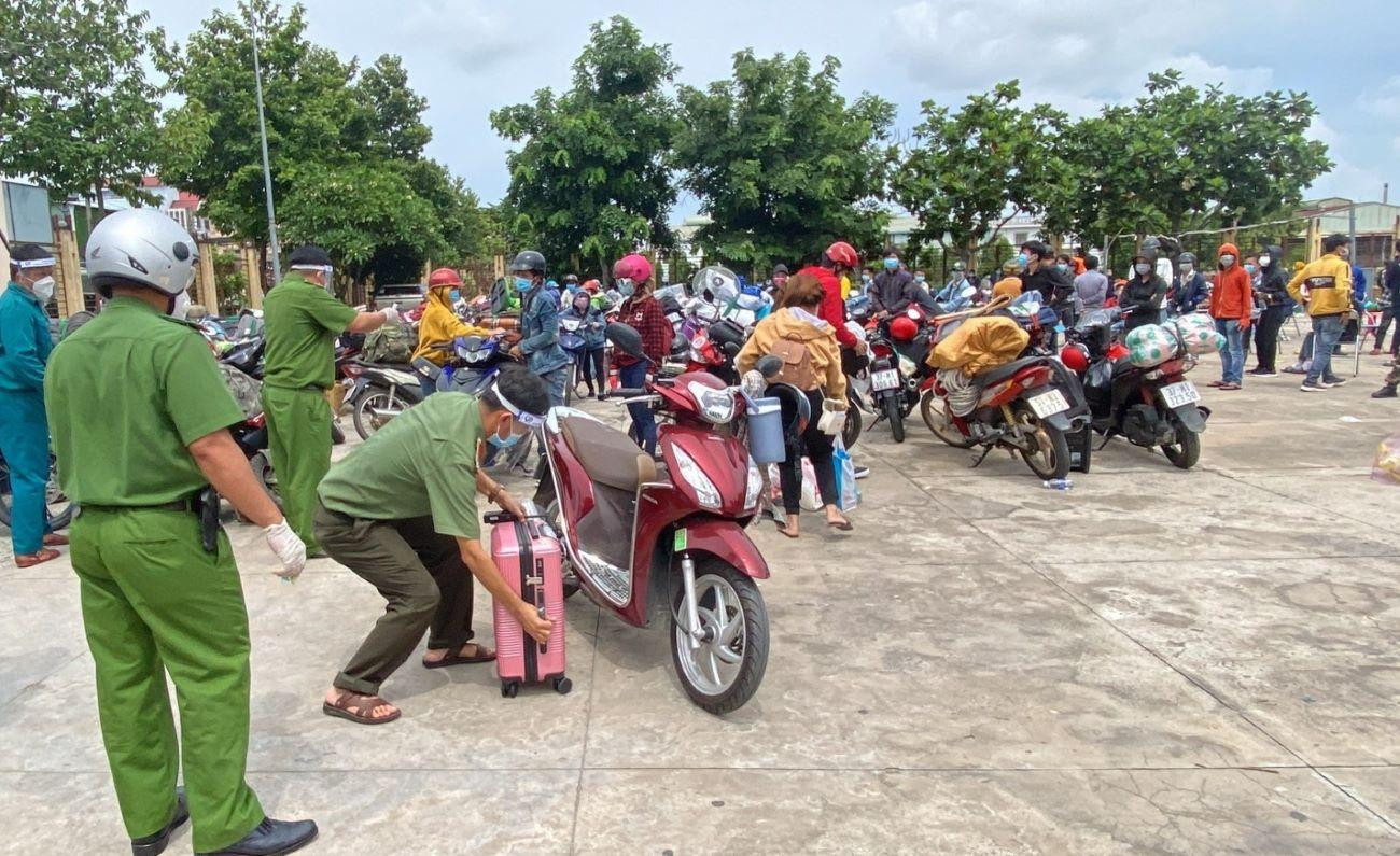 Lực lượng chức năng di chuyển những người đi xe máy đến nơi an toàn để xét nghiệm, phát thức ăn