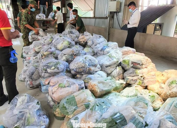 Lực lượng quân sự TX Tân Uyên, TP Thuận An phối hợp lực lượng đoàn thể do UBND hai địa phương này phân công, đảm nhận nhiệm vụ phân phát theo khối lượng 7,5kg/người/lần đến từng hộ dân. Trong ảnh: Rất nhiều hàng hóa sẽ được sắp xếp từng phần để phát cho người dân