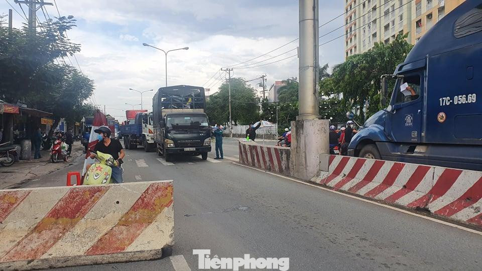 Lượng xe cộ ở các cửa ngõ chung cảnh nối đuôi nhau. Lý do ùn tắc do đầu vào các địa phận đều lập chốt kiểm dịch. Lực lượng chức năng chia nhau ra từng làn để sử dụng điện thoại quét mã QR và kiểm tra giấy tờ xét nghiệm. Trong ảnh: Lượng phương tiện đi lại trên đường ĐT 743 khá đông đúc.