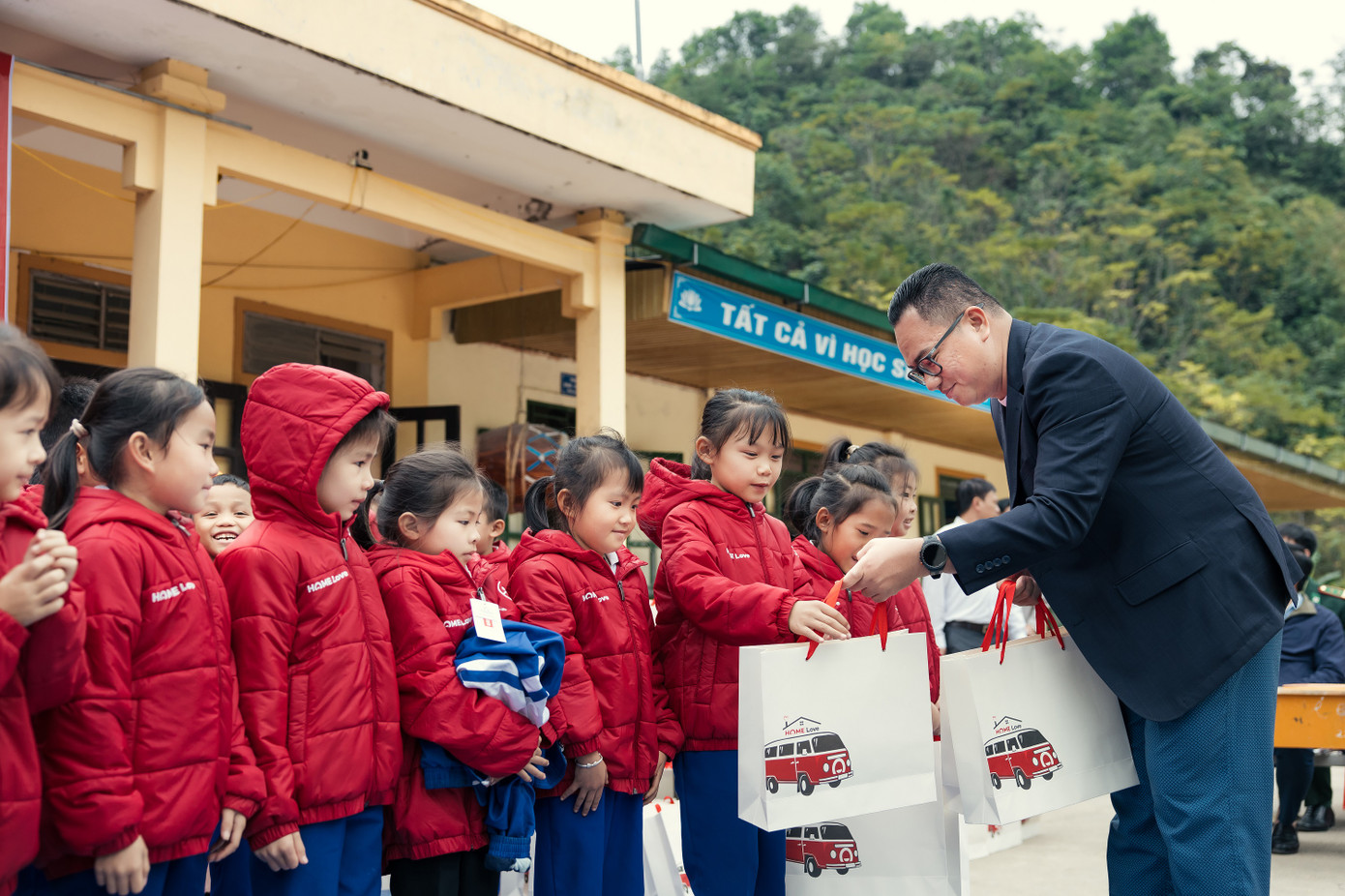 Đại diện Home Credit trao quà cho các em học sinh Mường Piệt. Ảnh: Home Credit