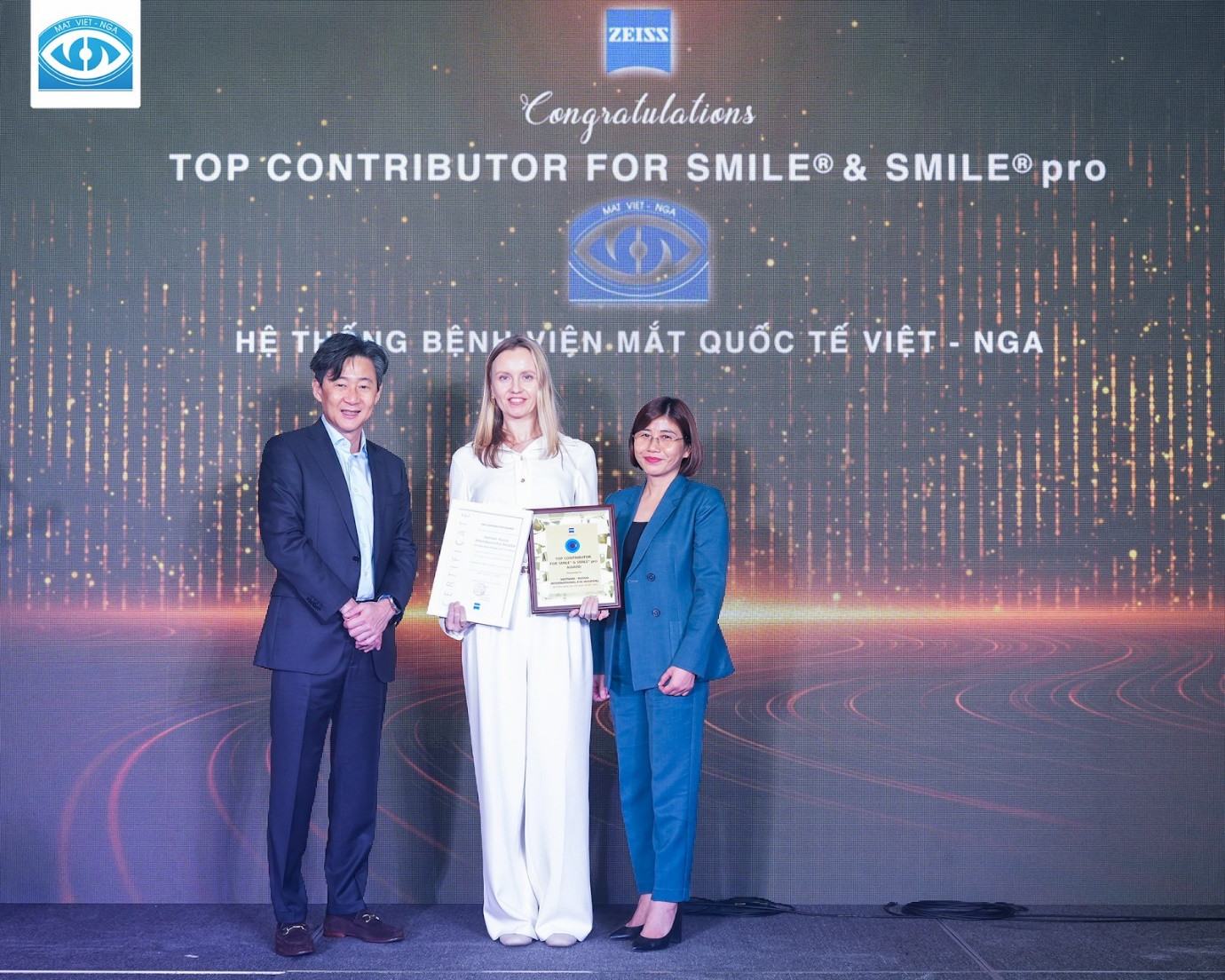Bác sĩ Daria Kolesnikova nhận Kỷ niệm chương Vinh danh “Đơn vị đóng góp lớn nhất trong hành trình xoá cận 10 triệu ca Smile và Smile Pro trên toàn thế giới” từ ông ông Han Peng Ng - Giám đốc ngành hàng thiết bị Carl Zeiss Đông Nam Á và bà Vũ Thị Thi Hiền - Tổng giám đốc Carl Zeiss Việt Nam