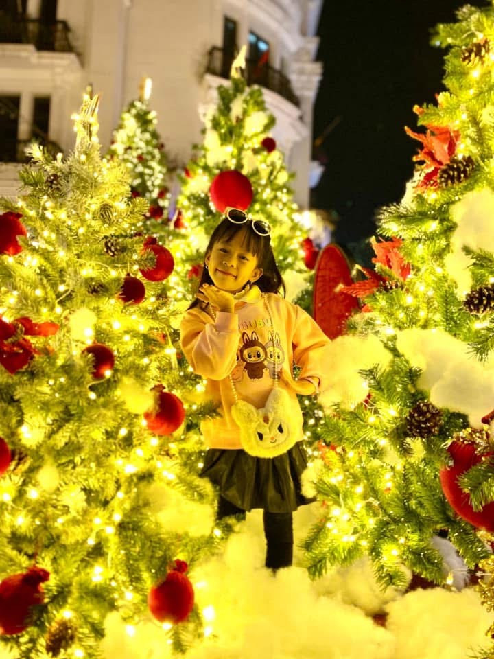 Các em nhỏ tạo dáng bên vườn thông khổng lồ rực rỡ sắc màu