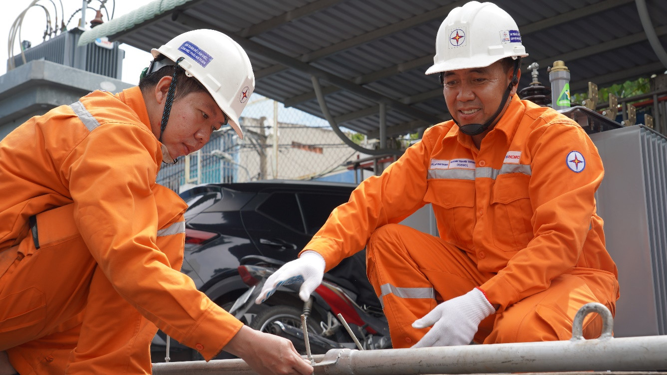 Anh Huỳnh Thanh Thuận (bìa phải) đang hướng dẫn sử dụng sáng kiến “Sào đỡ cáp ngầm”