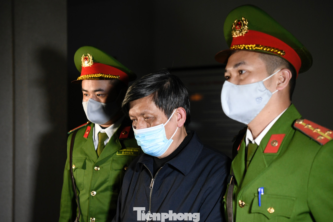 Cảnh sát dẫn giải cựu Bộ trưởng Bộ Y tế Nguyễn Thanh Long ra xe chuyên dụng.