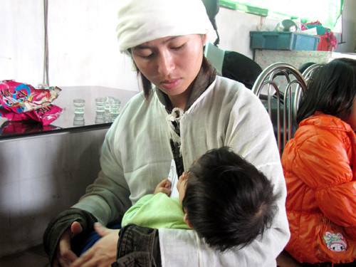 Vợ nạn nhân Nguyễn Quang Hạnh và con nhỏ. Ảnh: Quang Long Vợ nạn nhân Nguyễn Quang Hạnh và con nhỏ