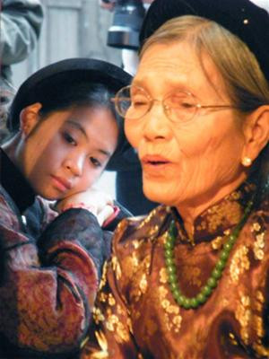 Một đào nương trẻ đang lắng nghe nghệ nhân Nguyễn Thị Chúc hát trong lễ giỗ tổ ca trù tại đình Lỗ Khê, Hà Nội tháng 12/2008 - Ảnh: N.M.Hà