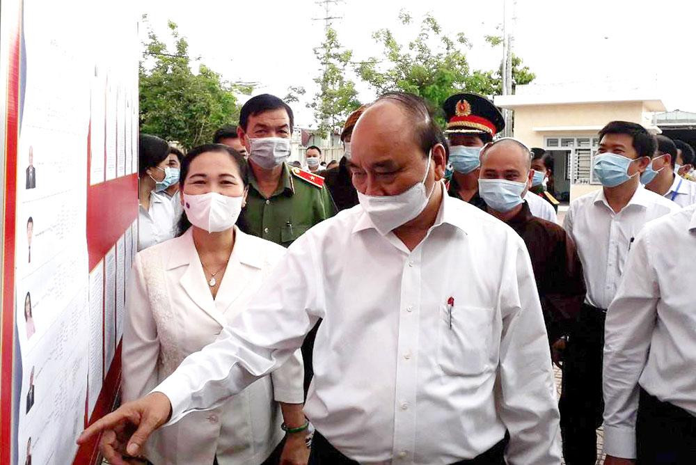 Chủ tịch nước Nguyễn Xuân Phúc kiểm tra nơi niêm yết danh sách người ứng cử đại biểu Quốc hội khóa XV tại Trung tâm Bồi dưỡng chính trị huyện Hóc Môn sáng 10/5