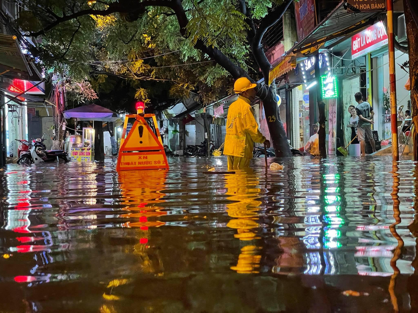 Công nhân xí nghiệp thoát nước dầm mưa khơi thông dòng chảy. Ảnh Trọng Tài