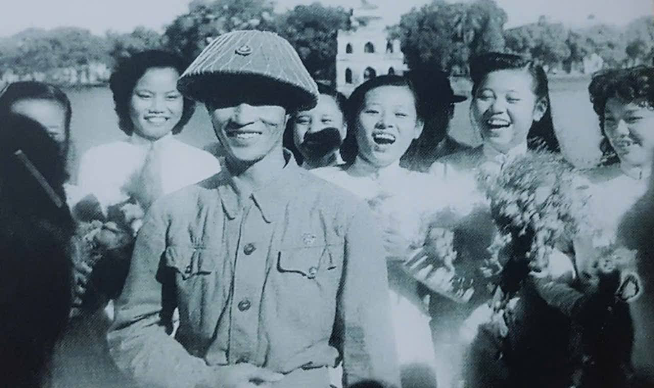 Các thiếu nữ Trường nữ sinh Trưng Vương và thiếu tướng Vương Thừa Vũ, Chủ tịch Ủy ban Quân quản Hà Nội trong ngày giải phóng Thủ đô.