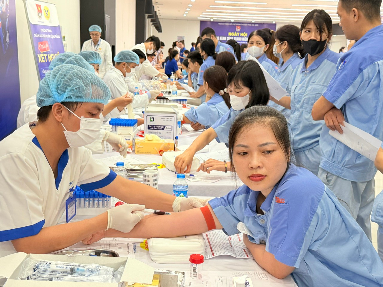 Đội ngũ y, bác sĩ lấy máu xét nghiệm cho thanh niên công nhân Đội ngũ y, bác sĩ lấy máu xét nghiệm cho thanh niên công nhân