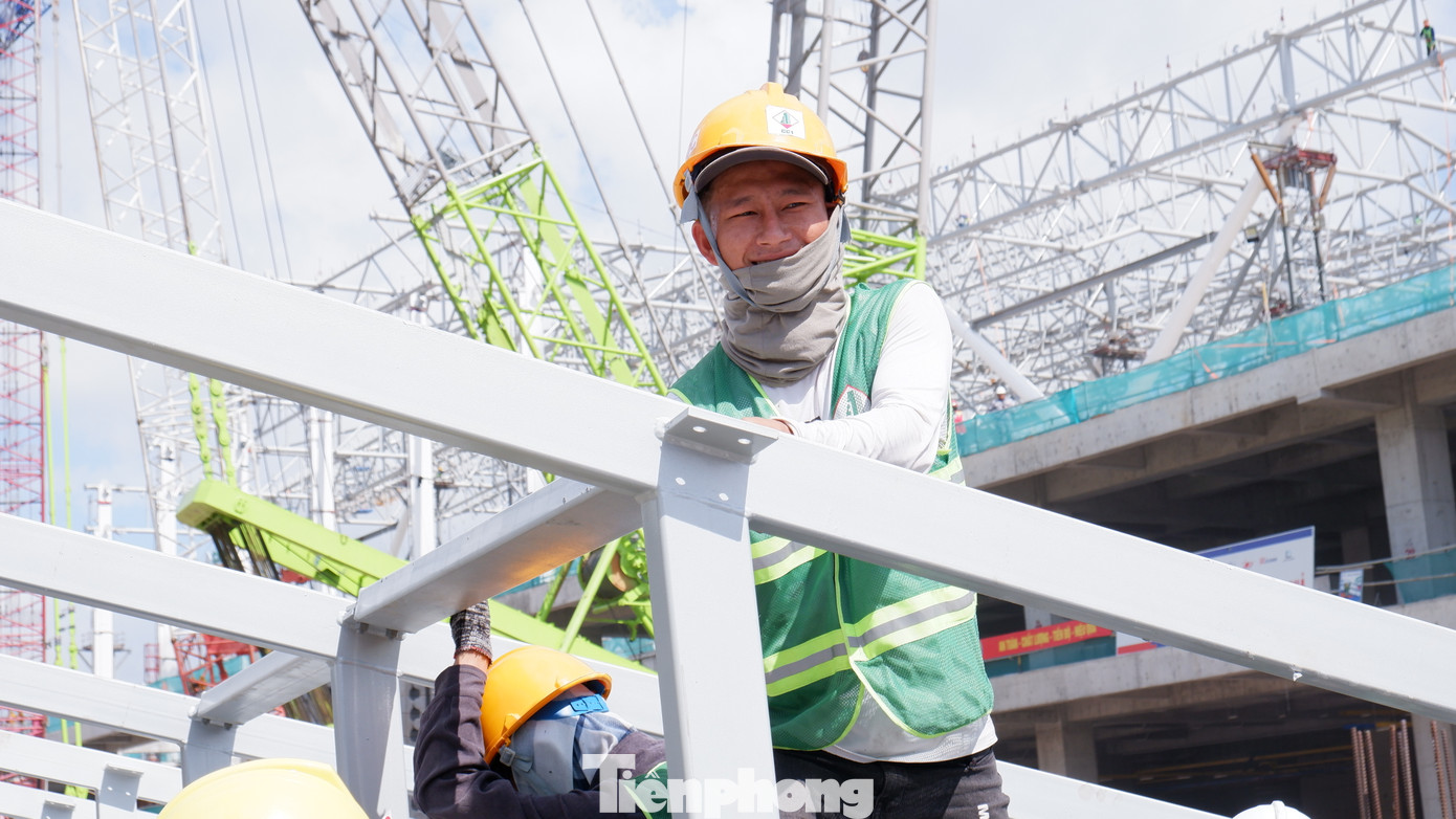Công nhân đội nắng, lắp ráp kết cấu thép tại công trường nhà ga T3. Ảnh: Hữu Huy