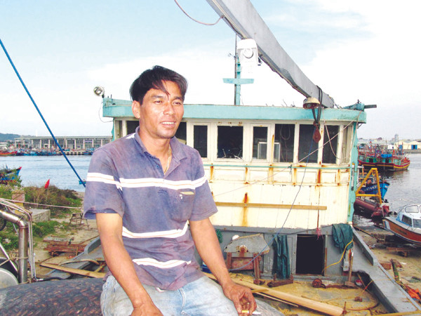 Thuyền trưởng Hồ Văn Minh trên con tàu ĐNa 90106 đang sửa chữa để ra khơi Ảnh: Bảo Lam