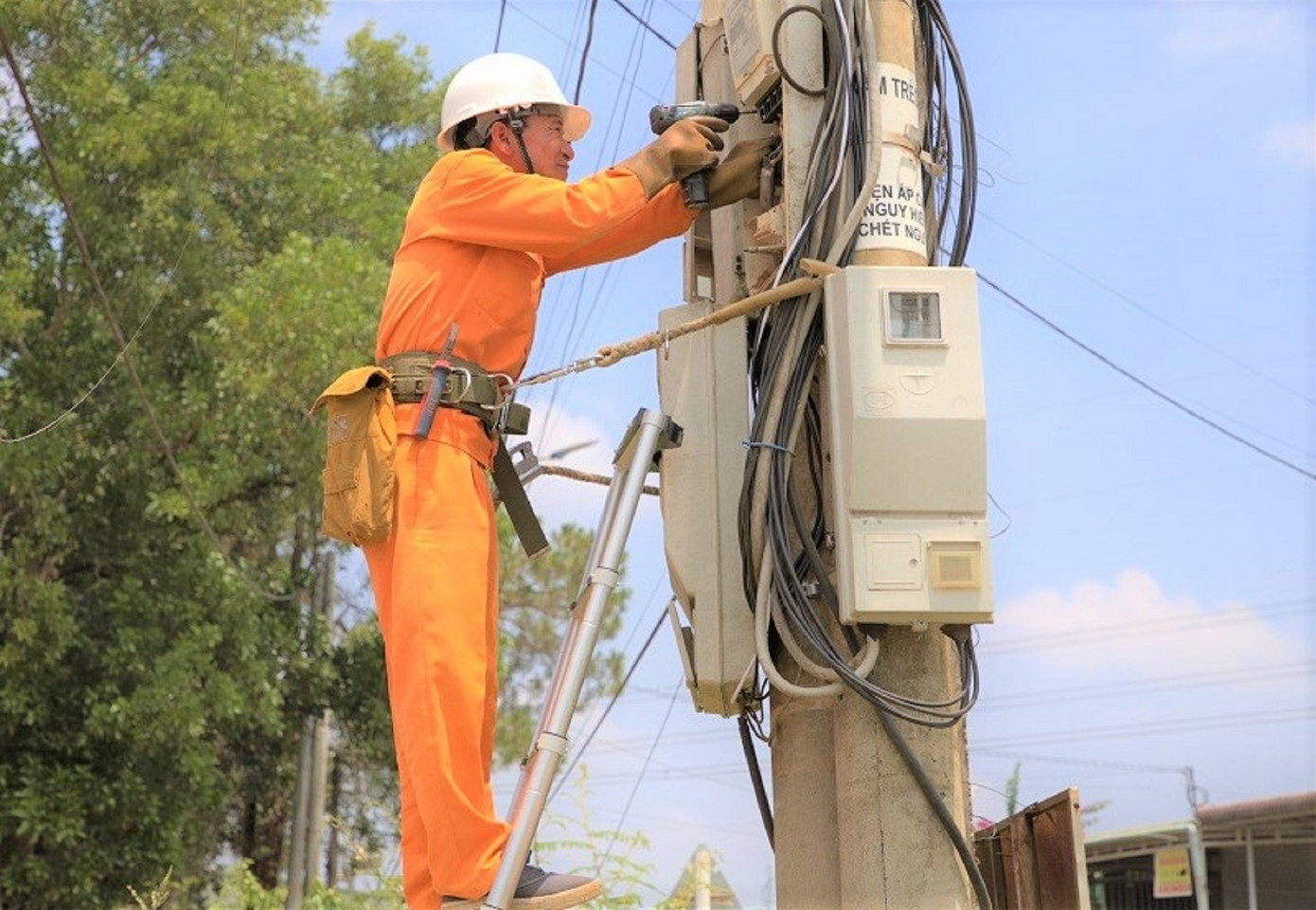 Nhân viên điện lực lắp công tơ điện tử và hệ thống tự động thu thập dữ liệu đo đếm từ xa