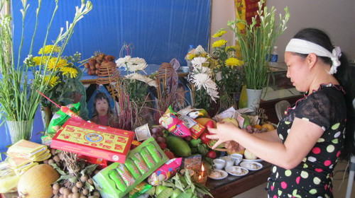 Người thân thắp hương trước bàn thờ gia đình vợ chồng anh Trịnh Thành Ngọc và chị Đinh Thị Chín - Ảnh: Thân Hoàng (Tuổi Trẻ)