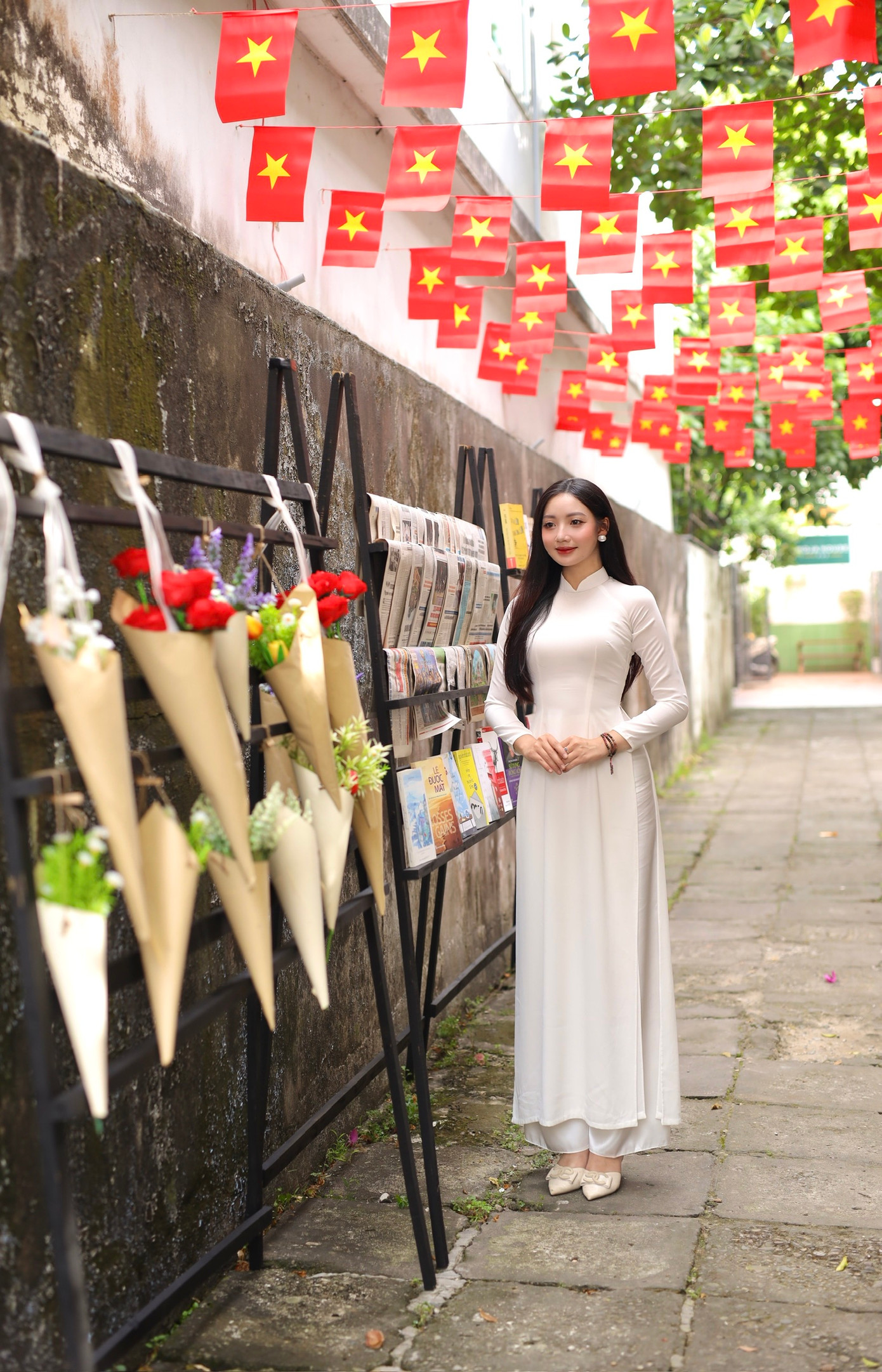 Mang trong mình niềm tự hào là một người con Việt Nam, Diễm Trinh trong tà áo dài trắng tinh khôi ở một con hẻm nhỏ, đầy những lá cờ đỏ sao vàng.