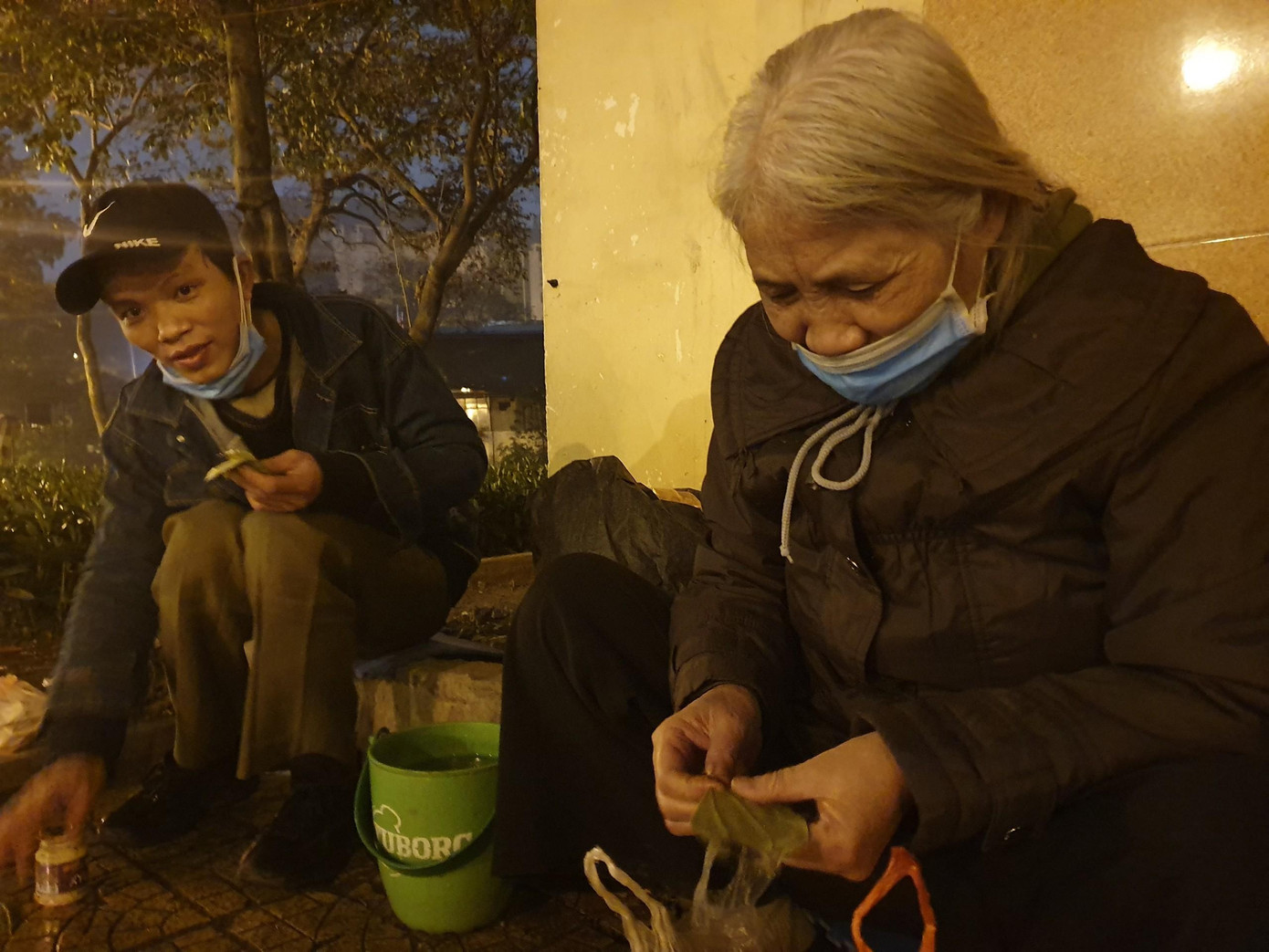 22h, Hà Nội đã chìm trong giá rét 8 độ C, lạnh nhất từ đầu mùa đông năm nay. Dưới mái hiên khu nhà quản lý hồ Thuyền Quang đã khóa trái là người phụ nữ đang thu dọn, loay hoay tìm cho mình chỗ ngả lưng. Thấy có khách ghé qua, cụ nhổm dậy têm trầu mời.