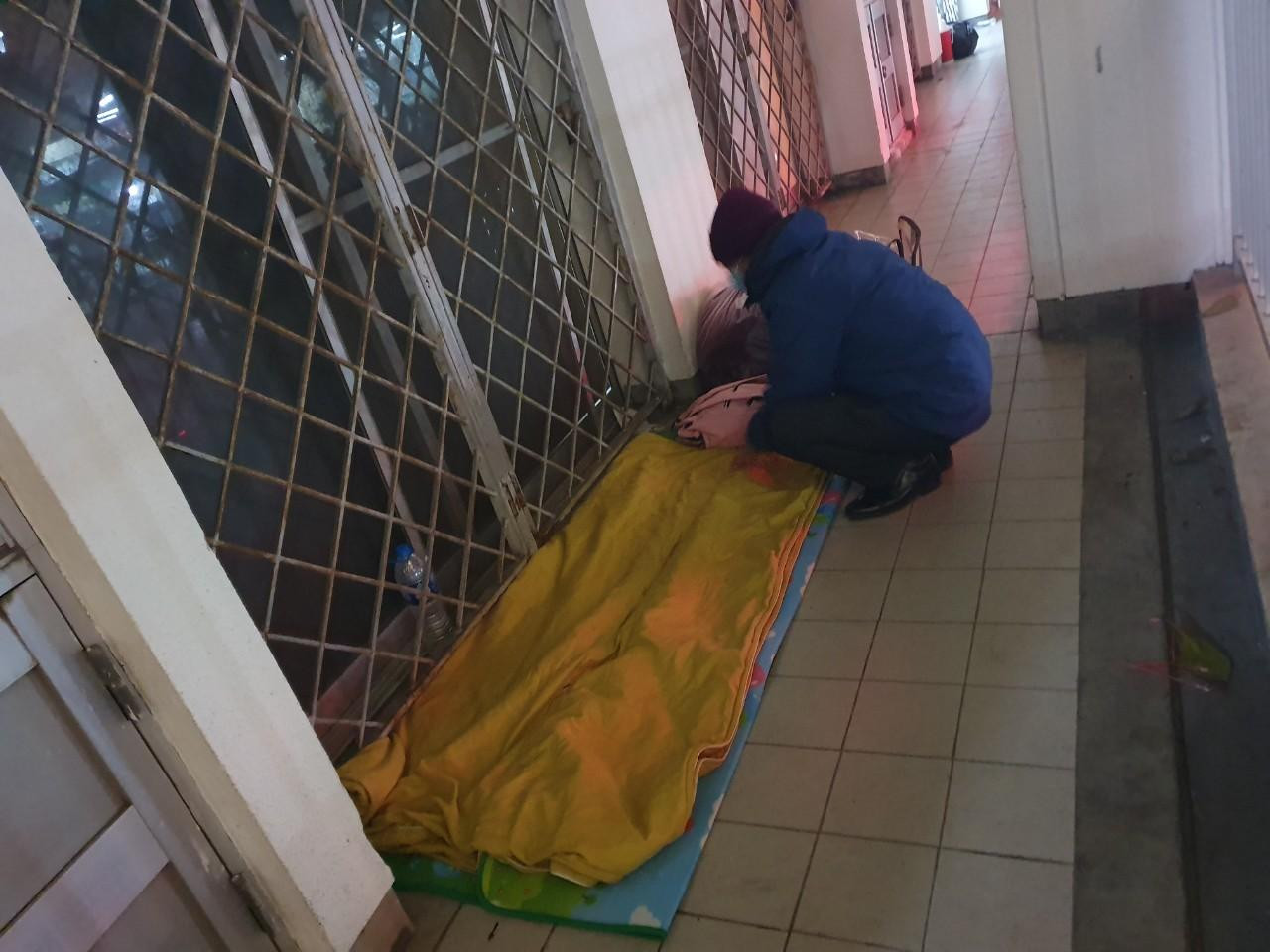 Càng về khuya gió lạnh càng thổi buốt, người nhà bệnh nhân tản mát dần, người thì dựng lều trong góc khuất gió, người trải chiếu trên hành lang, người nằm vạ vật trên băng ghế đá.