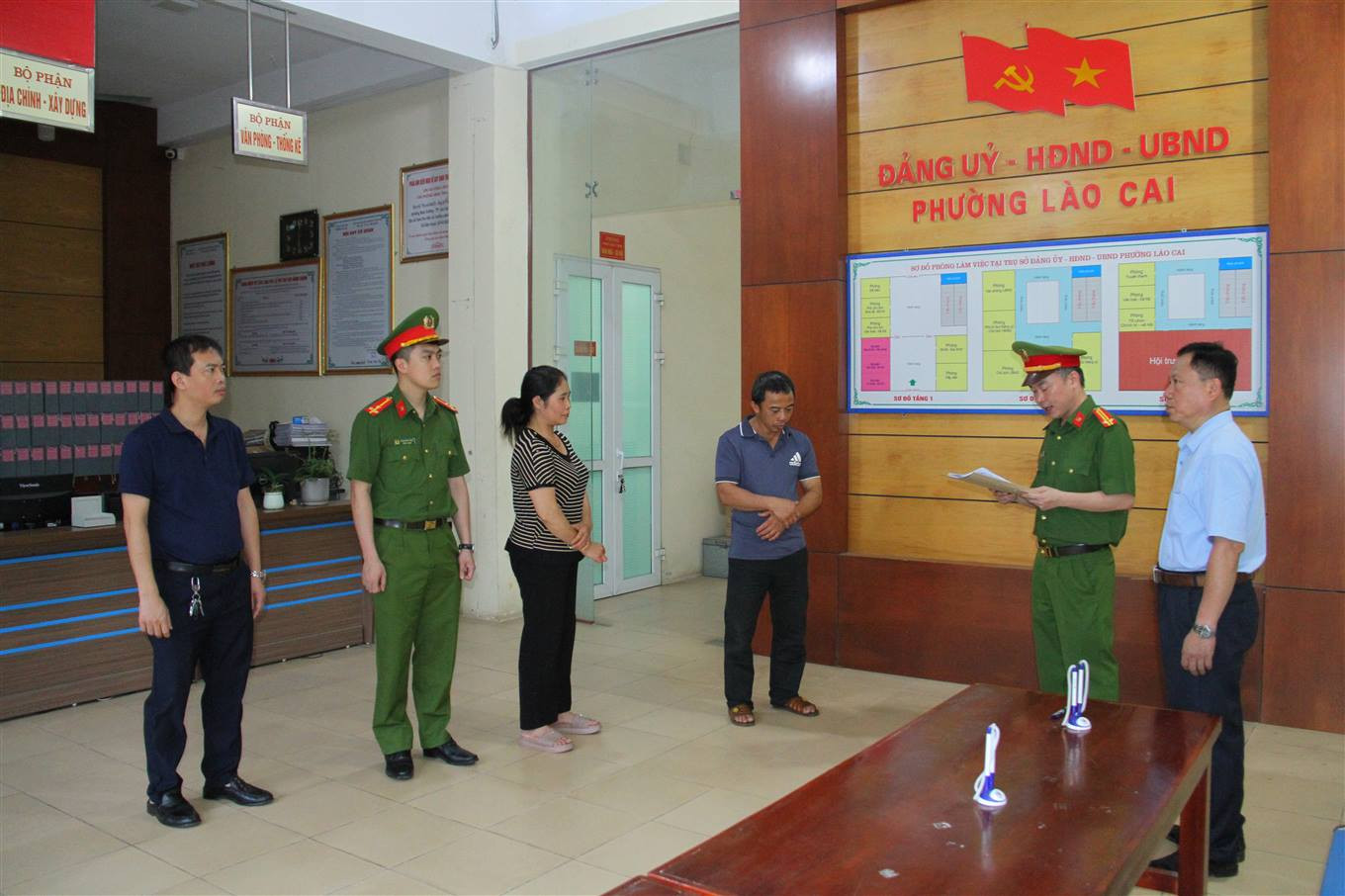 Cơ quan Cảnh sát điều tra đọc quyết định khởi tố bị can và lệnh cấm đi khỏi nơi cư trú đối với bị can T. V. Hải và L. T. Th. Ảnh: Quỳnh Trang.