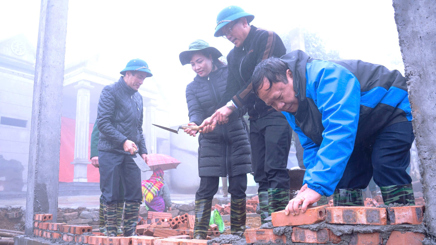 Ông Nguyễn Trọng Hài, Phó Chủ tịch UBND tỉnh (người cầm gạch xây) và lãnh đạo các sở, ngành tỉnh, huyện Mường Khương tham gia xây dựng nhà cùng hộ dân.