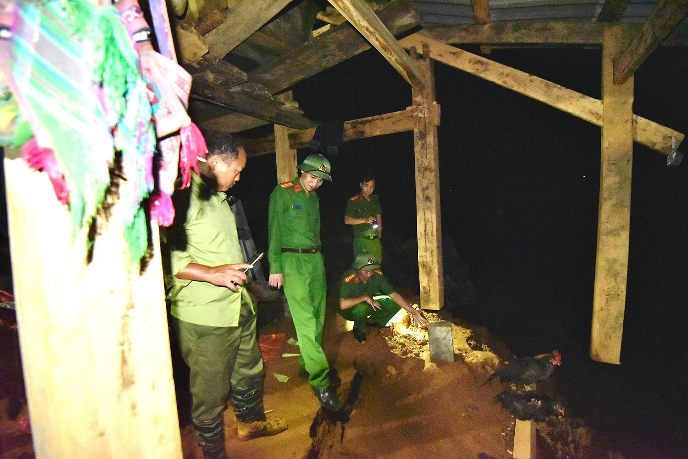 Công an phường Sa Pa cùng lực lượng an ninh cơ sở tuyên truyền vận động và hỗ trợ hai hộ dân thuộc tổ 3 di chuyển khỏi địa điểm sạt lở đến nơi an toàn. Ảnh: Tống Huệ