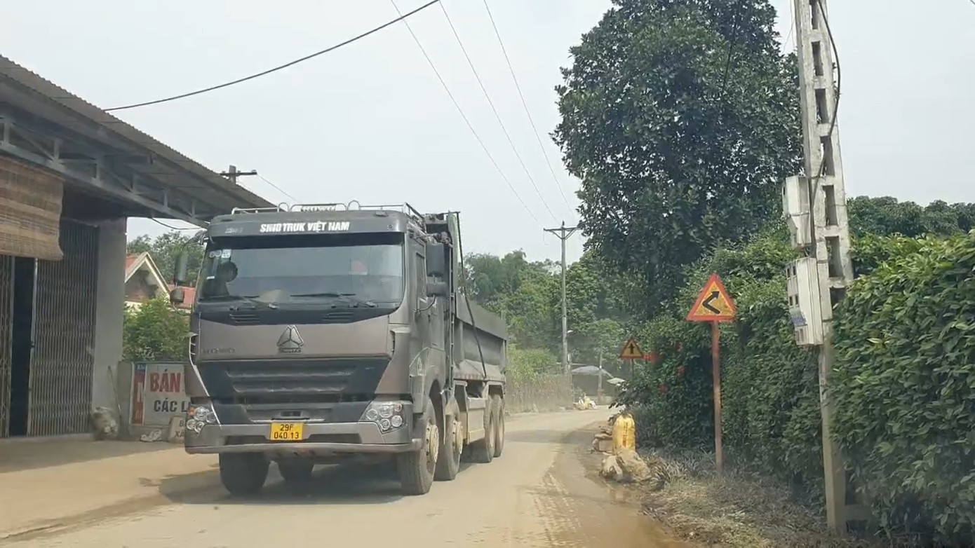 Dù đã bị cắt thùng thành nhưng những xe này vẫn được cơi nới, đất chất lên cao vút. Nhiều đoạn đường, để tránh xe tải chạy qua va quệt vào tường nhà, vườn người dân phải xếp những hòn đá lớn ra lề đường để che chắn.