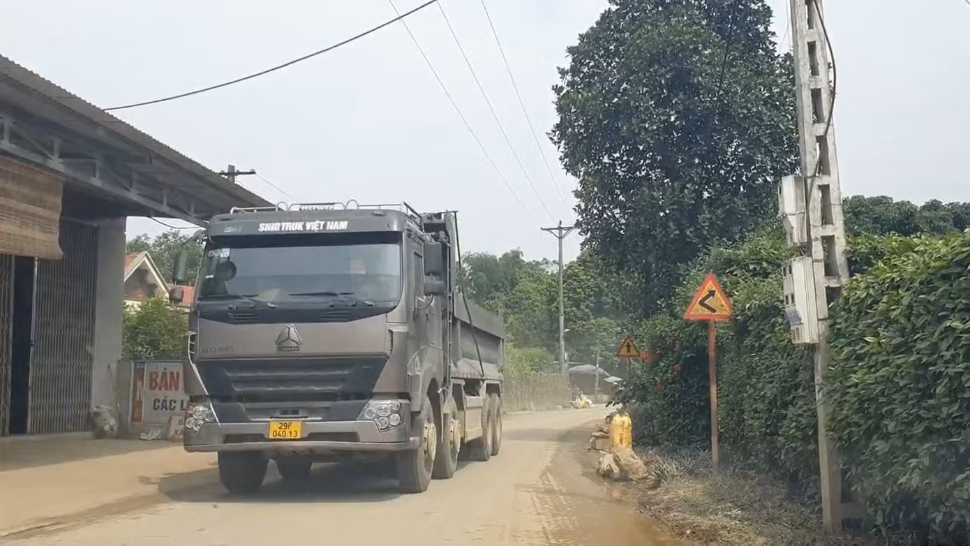 Dù đã bị cắt thùng thành nhưng những xe này vẫn được cơi nới, đất chất lên cao vút. Nhiều đoạn đường, để tránh xe tải chạy qua va quệt vào tường nhà, vườn người dân phải xếp những hòn đá lớn ra lề đường để che chắn.