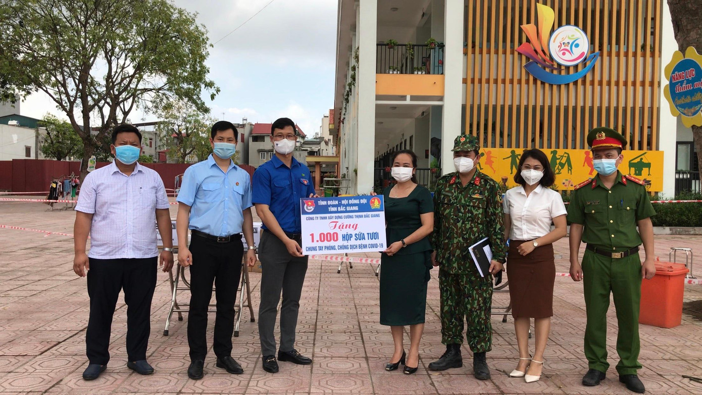 Cận kề ngày Tết Thiếu nhi, nhiều em nhỏ tại tâm dịch Bắc Giang trong khu cách ly và bệnh viện điều trị COVID-19 bất ngờ nhận được những món quà. Dù chỉ là túi bánh kẹo hay lốc sữa nhưng niềm vui hiện rõ trong những đôi mắt trong trẻo sau nhiều ngày “cách ly” với cộng đồng. Trong ảnh, anh Thân Trung Kiên, Bí thư Tỉnh Đoàn Bắc Giang (áo xanh từ trái sang) trao quà cho các em tại một trung tâm cách ly ở trường mầm non.