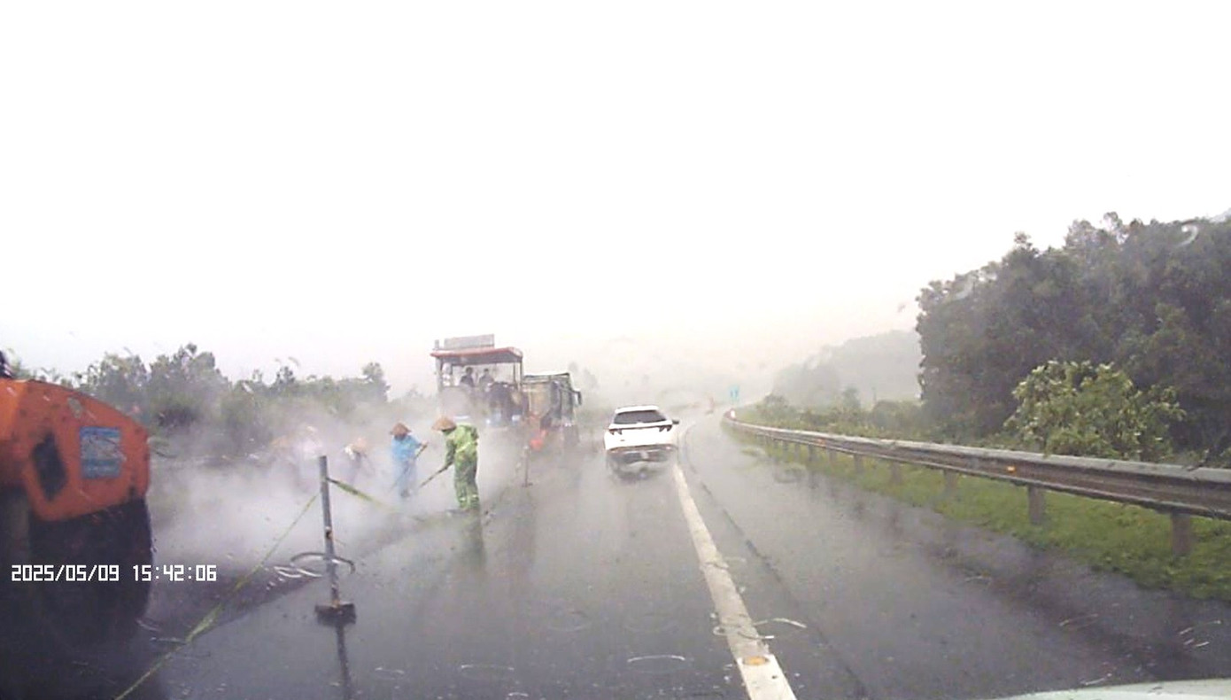 Từ trưa đến chiều ngày 9/5, nhiều nơi tại tỉnh Yên Bái, Phú Thọ mưa rất lớn. Tuy nhiên, đơn vị thi công trên cao tốc Nội Bài - Lào Cai vẫn trải thảm mặt đường. Hình ảnh ghi nhận của phóng viên lúc 15h42 ngày 9/5 cho thấy, tại Km 96 của tuyến cao tốc này (thuộc địa bàn tỉnh Phú Thọ), dù trời mưa to nhưng công nhân và máy móc vẫn san gạt lớp nhựa đổ xuống để cho xe lu đi qua.