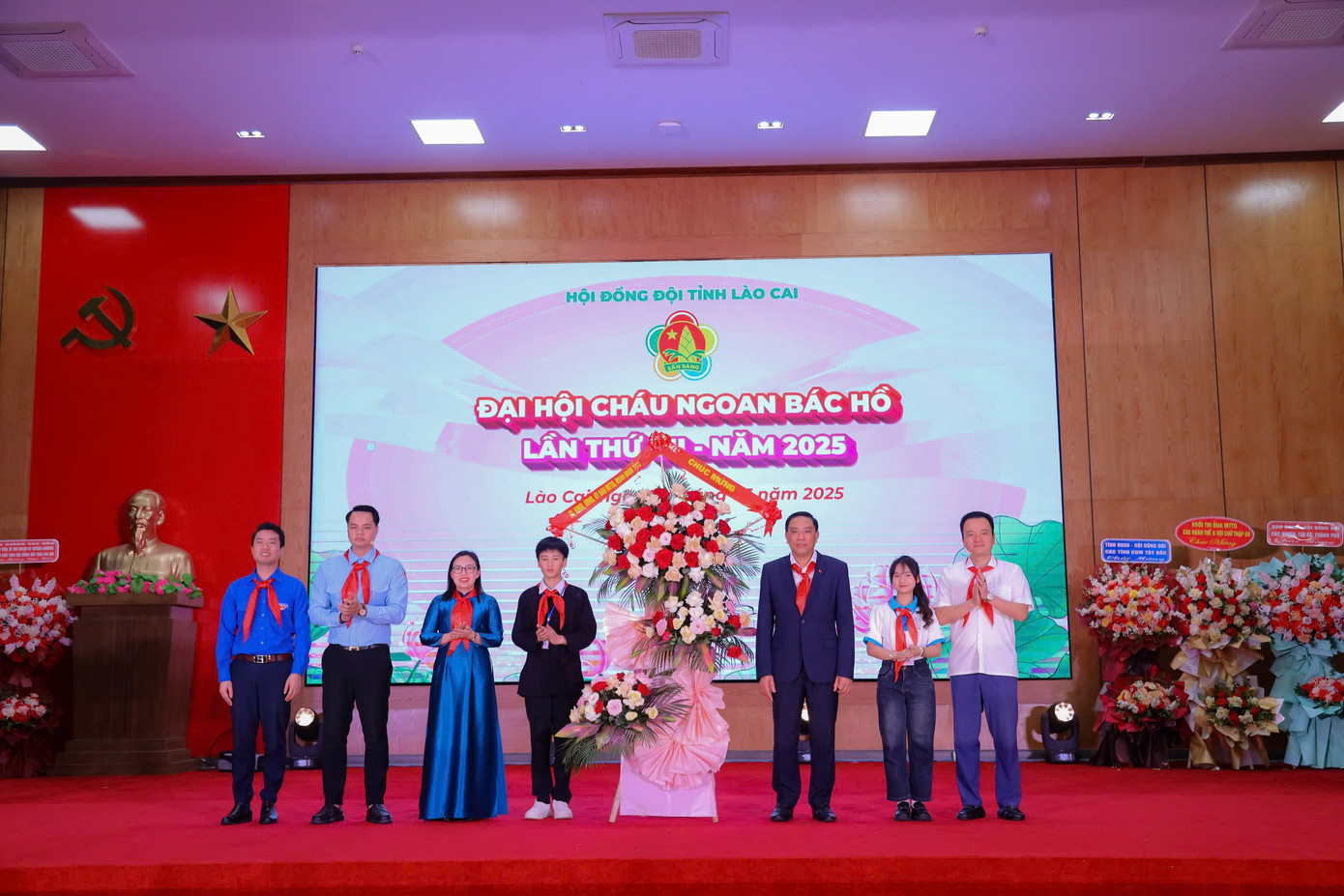 Ông Hoàng Giang, Phó Bí thư Tỉnh ủy Lào Cai biểu dương và đánh giá cao những nỗ lực của thiếu nhi Lào Cai trong 5 năm qua. Phong trào Đội tại tỉnh đã có bước phát triển mạnh mẽ, toàn diện, góp phần quan trọng vào công tác giáo dục thế hệ trẻ. Các phong trào “Nghìn việc tốt”, “Hoa điểm 10”, “Đôi bạn cùng tiến”, cùng nhiều mô hình sáng tạo như “Giờ ra chơi trải nghiệm”, “Học làm chiến sĩ công an”, “Nhà vệ sinh cho em”... Các phong trào đã tạo dấu ấn sâu đậm trong lòng cộng đồng. Trong ảnh: Ông Hoàng Giang (đứng thứ 3 bên phải) tặng hoa chúc mừng đại hội. Ông Hoàng Giang, Phó Bí thư Tỉnh ủy Lào Cai biểu dương và đánh giá cao những nỗ lực của thiếu nhi Lào Cai trong 5 năm qua. Phong trào Đội tại tỉnh đã có bước phát triển mạnh mẽ, toàn diện, góp phần quan trọng vào công tác giáo dục thế hệ trẻ. Các phong trào “Nghìn việc tốt”, “Hoa điểm 10”, “Đôi bạn cùng tiến”, cùng nhiều mô hình sáng tạo như “Giờ ra chơi trải nghiệm”, “Học làm chiến sĩ công an”, “Nhà vệ sinh cho em”... Các phong trào đã tạo dấu ấn sâu đậm trong lòng cộng đồng. Trong ảnh: Ông Hoàng Giang (đứng thứ 3 bên phải) tặng hoa chúc mừng đại hội.