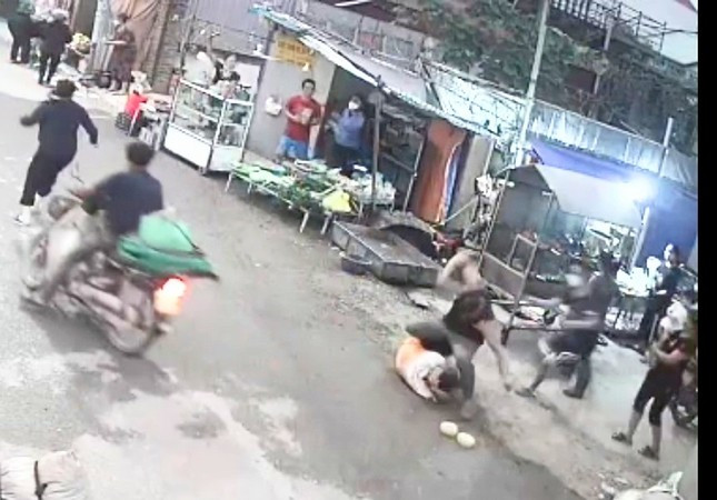 Hình ảnh camera được trích xuất từ hộ dân gần đó cho thấy, Đoàn (mặc áo đen, to lực lưỡng) đấm liên tục vào mặt, đầu anh Tú.