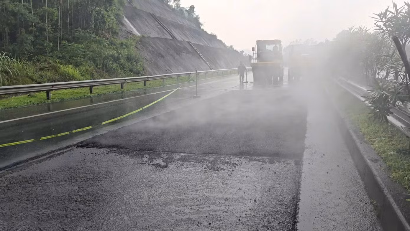 Thấy phóng viên ghi hình, công nhân lập tức ngừng làm việc. Nhưng một lúc sau, khi mưa nhỏ hơn, công nhân và xe lu lại tiếp tục làm việc.