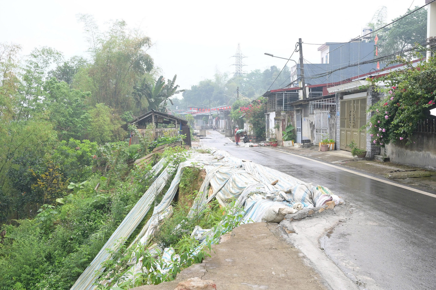 Một đoạn đường bị sạt trượt, tụt sâu, nguy cơ trôi cả mảng đất lớn xuống dãy dân cư ở phía dưới chân taluy.